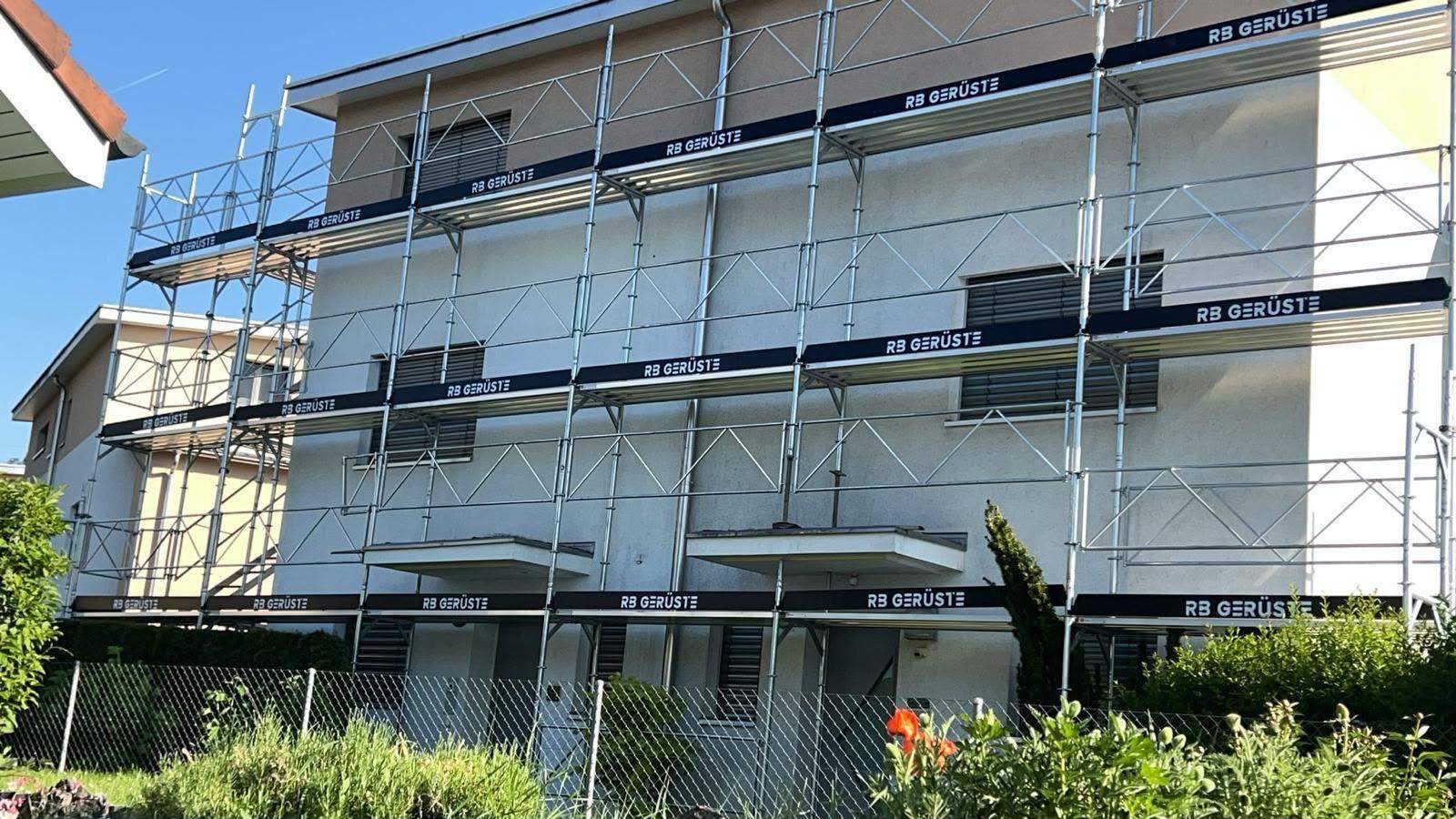 Fassadengerüst von RB Gerüste an einem Wohnhaus, Bordbretter mit Firmenschriftzug «RB Gerüste»